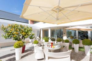 罗马JC酒店的庭院配有桌椅和遮阳伞。