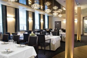 兹邦申森纳特酒店的用餐室配有白色桌椅和吊灯。