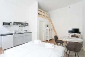柏林Studio Apartment for 3的白色的厨房配有桌子和两把椅子