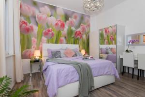 扎达尔莱尼宾馆的卧室配有一张墙壁上粉红色鲜花的床。