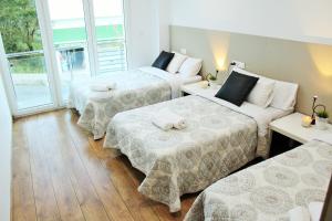 MazaricosApartamentos Camino De Finisterre的酒店客房设有三张床和窗户。