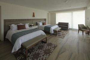 瓜达拉哈拉天鹅绒广场酒店的酒店客房,配有两张床和椅子