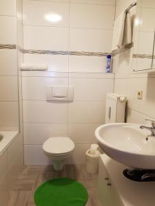 鲁斯特Ferienwohnung Zoja的白色的浴室设有卫生间和水槽。
