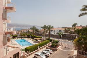 埃拉特Apartment in Amdar Residence的享有停车场、汽车和游泳池的景色