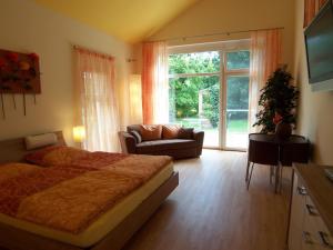 莱茵河畔凯尔巴德策乡村绿洲酒店的一间卧室配有一张床、一张沙发和一个窗口