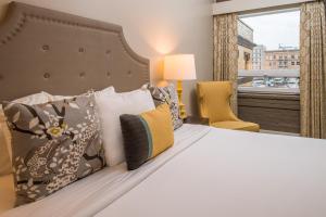波特兰马克史宾塞酒店的卧室配有带枕头的床铺和窗户。