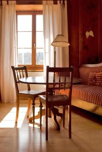 La FerrièreHôtel de la Chaux-d'Abel的配有桌子、两把椅子和一张沙发的房间