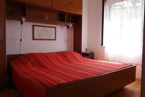 尼亚卢卡Apartmani Surjan的一间卧室配有一张床铺,床上铺有红色毯子