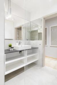 波兹南Venezia Apartment的白色的浴室设有水槽和镜子