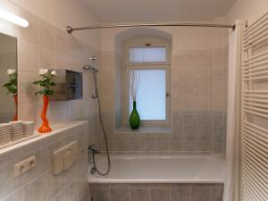 德累斯顿Neustadt - Paradies的带浴缸的浴室和窗户上的花瓶