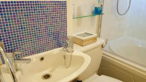 布莱克浦盖布瑞拉酒店的带浴缸、卫生间和盥洗盆的浴室