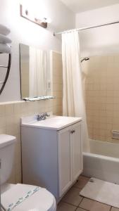 洛杉矶洛杉矶市中心酒店的浴室配有盥洗盆、卫生间和浴缸。