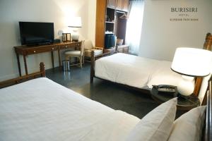 清迈布里斯里精品酒店的客房设有两张床和一张书桌及一台电视。
