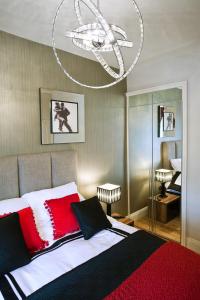 切尔滕纳姆波特兰公寓酒店的一间卧室配有一张带红色和白色枕头的大床