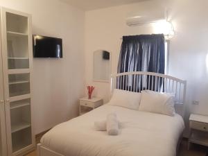 纳哈里亚אבני החושן- Avnei Hoshen的一间卧室配有一张带白色床单的床和一扇窗户。