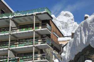 布勒伊-切尔维尼亚莫里诺酒店的一座被雪覆盖的建筑,背景是一座山