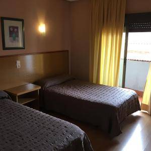 莱加内斯莱加内斯阿文尼达酒店的酒店客房设有两张床和窗户。
