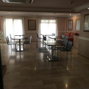 莱加内斯莱加内斯阿文尼达酒店的用餐室设有桌椅和窗户。