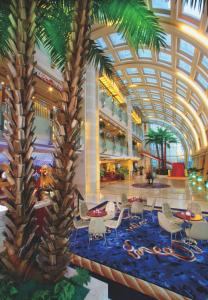 大连大连星海假日酒店的大堂设有棕榈树和桌椅