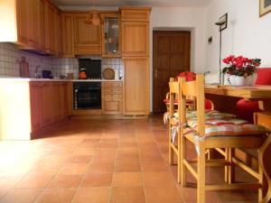 卡尔切拉尼卡阿拉戈Maso Pianezza House的厨房配有木制橱柜和桌椅