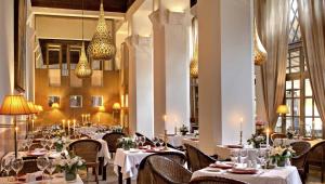 马拉喀什麦地那亚尔丁斯的餐厅设有白色的桌椅和吊灯。