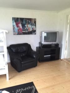 尤城Rolösa的客厅配有黑色真皮沙发和电视