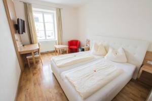 Obernberg am Inn卡斯图夫博斯特酒店的卧室配有白色的床和红色椅子