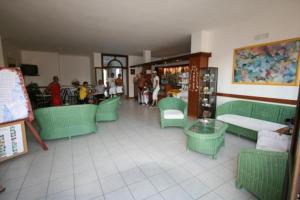 奥斯图尼芭芭拉俱乐部之家的一间设有绿色椅子和桌子的餐厅,可供住客用餐