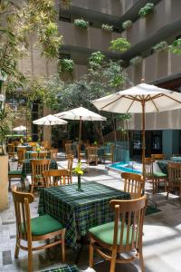 托卢卡旧金山酒店的一个带桌椅和遮阳伞的户外庭院。