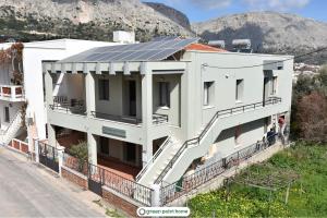 弗隆塔多斯Green Point Home Chios的屋顶上设有太阳能电池板的白色建筑