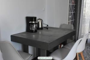 弗隆塔多斯Green Point Home Chios的一张带椅子的黑桌子和咖啡壶
