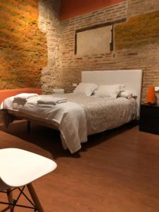 塞哥维亚自然广场旅馆的一间卧室设有一张床和砖墙