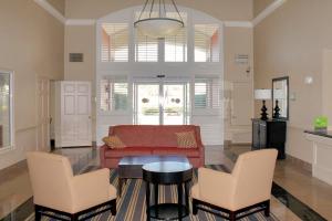 休斯顿美国长住酒店-休斯顿-医学中心-NRG公园-布雷斯伍德大道的客厅配有红色的沙发和两把椅子