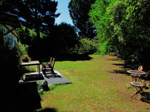 West MeltonNut Point Cottage的一个带椅子和桌子的庭院和一张野餐桌