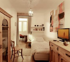 的里雅斯特Boutique Hotel Albero Nascosto的一间卧室配有一张床、一台电视和一张书桌