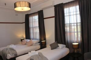 Guildford吉尔福德酒店的带窗户的酒店客房内的两张床