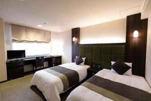 京都嵯峨岚山比纳里奥酒店的酒店客房配有两张床和一张书桌