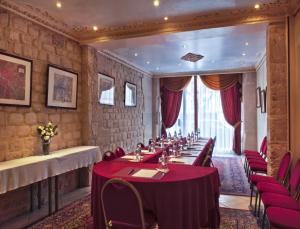 巴黎米诺夫酒店的一间设有桌子和红色椅子的长餐厅