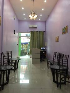 利帕Meaco Royal Hotel - Lipa的用餐室配有椅子、桌子和紫色墙壁