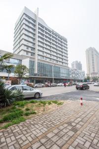 合肥锦江都城合肥天鹅湖酒店的大型建筑前的停车场,有车辆停放