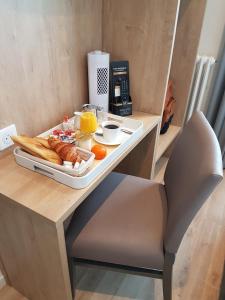 凯恩Hôtel Mary's - Caen Centre Gare Sncf的桌椅上的一盘早餐食品