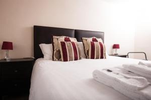 布兰登布兰登桥梁酒店的卧室配有带枕头和两盏灯的白色床。