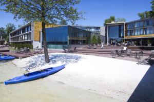 奥尔什丁避风港酒店与spa的蓝色的皮艇坐在建筑物前的沙子上