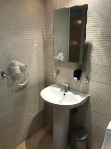 科斯镇雅尼斯开普敦公寓的一间带水槽和镜子的浴室