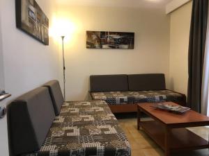 科斯镇雅尼斯开普敦公寓的客厅配有沙发和桌子