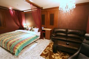 DaitōSari Resort Daito (Adult only)的一间卧室配有一张床和一张黑色皮椅