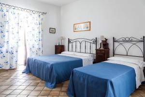 圣马里纳萨利纳Hotel Mercanti di Mare的配有蓝色床单的客房内的两张床