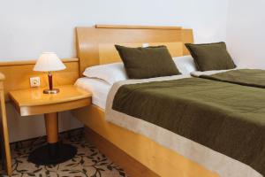 兹雷切温泉兹热西 - 活力酒店的一间卧室配有两张床和一张带台灯的桌子
