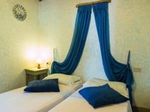 尼阿博勒皮耶韦Belvilla by OYO Nice Farmhouse with Sauna Jacuzzi的卧室内的两张床,带蓝色窗帘