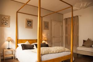 蓬蒂维莱斯尚布勒斯鲁尔梅尔酒店的卧室配有带白色床单和枕头的天蓬床。
